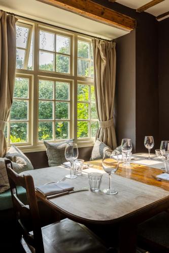 a dining room with a table with wine glasses on it at The Ebrington Arms in Chipping Campden