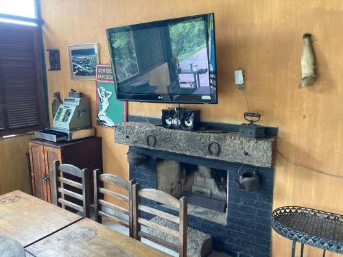 ein Wohnzimmer mit einem Kamin und einem TV darüber. in der Unterkunft Chácara Recanto do Sossego in Igaratá