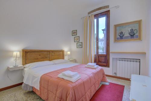 una camera da letto con un letto e due asciugamani di MORO get-by-train a Venezia