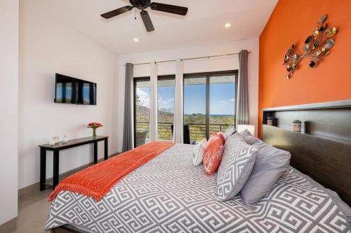 una camera con un letto con una parete arancione di Casa Blanca a Playa Hermosa
