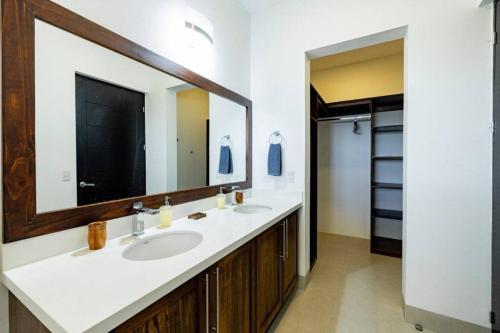 a bathroom with two sinks and a large mirror at Casa Blanca in Playa Hermosa