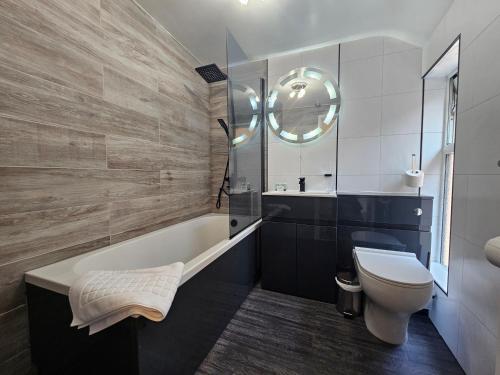 a bathroom with a tub and a toilet and a sink at ABBEY HOTEL in Stafford