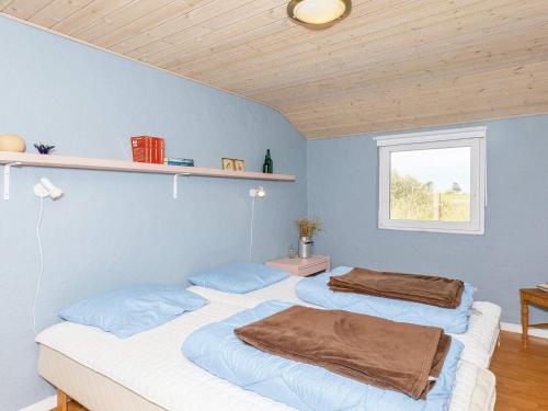 2 camas en una habitación con paredes azules y ventana en Luxurious Holiday Home in Thyholm with Sauna en Thyholm