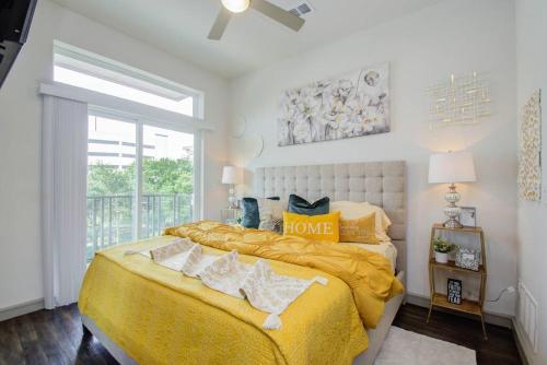 a bedroom with a large bed with a yellow blanket at Luxury Living Downtown Houston Kingbed. in Houston