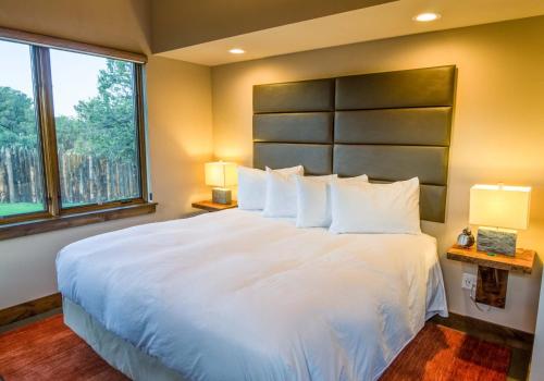 a bedroom with a large white bed with a large window at Royal Gorge Cabins in Buckskin Joe