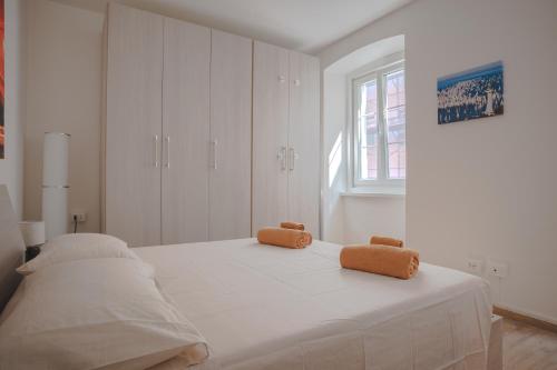 ein weißes Schlafzimmer mit einem Bett mit zwei Teddybären darauf in der Unterkunft [Largo Barriera] Elegant Apartment *Netflix+WiFi* in Triest