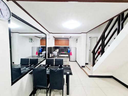 Una sala de conferencias con una mesa y sillas y un reloj. en Calapan City Fully Furnished House Transient near XentroMall L39, en Calapan