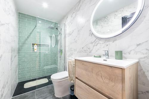 a bathroom with a toilet and a sink and a mirror at Sea la vi in Puerto Rico de Gran Canaria
