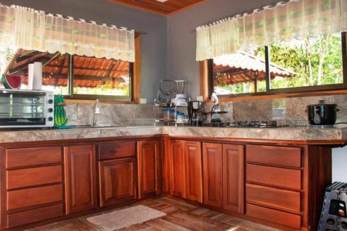 eine Küche mit Holzschränken und einer Arbeitsplatte in der Unterkunft Quinta Los Sueños, San Carlos in Aguas Zarcas
