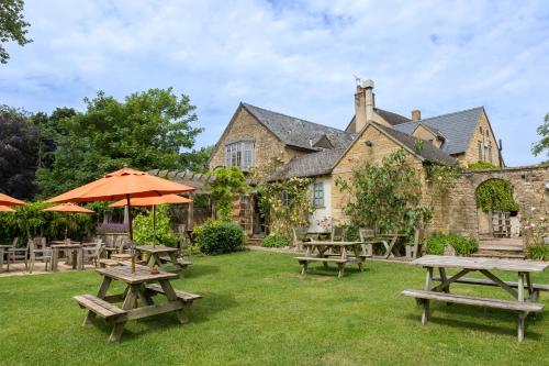 a group of picnic tables in front of a building at The Ebrington Arms in Chipping Campden