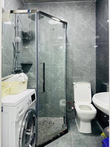 a bathroom with a shower with a toilet and a sink at KERUEN SARAY APARTMENTS 20/2 in Türkistan