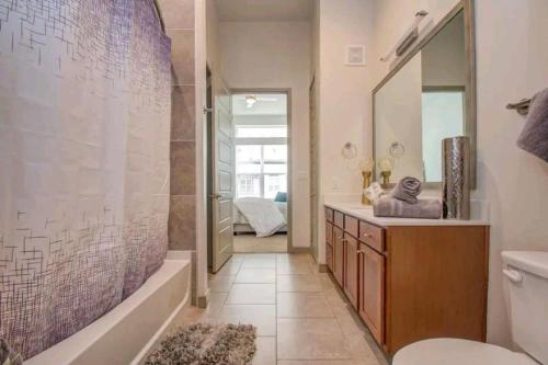 a bathroom with a tub and a sink and a mirror at Coolest Luxury Palace Downtown in Houston