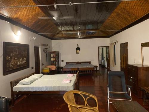 Schlafzimmer mit einem Bett, einem Tisch und Stühlen in der Unterkunft Gramam Homestay, Cochin in Kochi