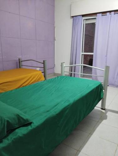 Habitación hospitalaria con cama con sábana verde en casa en Gualeguaychú en Gualeguaychú