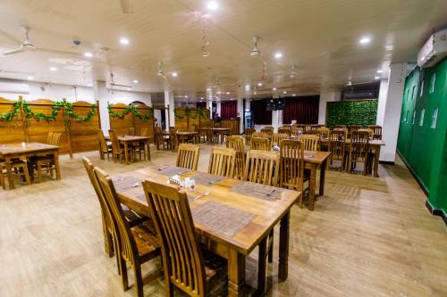 une salle à manger avec des tables et des chaises en bois dans l'établissement Pearl Island Inn, à Jaffna