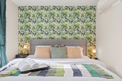 費城的住宿－1 BR Passyunk Ave Stunner- Perfect Location，一间卧室配有一张带绿色和白色毯子的床
