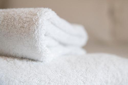 a pile of white towels sitting on a bed at ABBEY HOTEL in Stafford