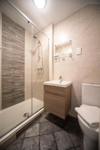 a bathroom with a sink and a shower and a toilet at ABBEY HOTEL in Stafford
