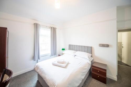 a bedroom with a white bed with a tray on it at ABBEY HOTEL in Stafford