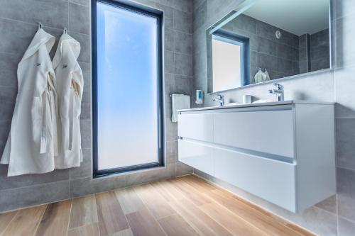 a bathroom with a sink and a large window at Tuscany Residence Aruba in Palm-Eagle Beach