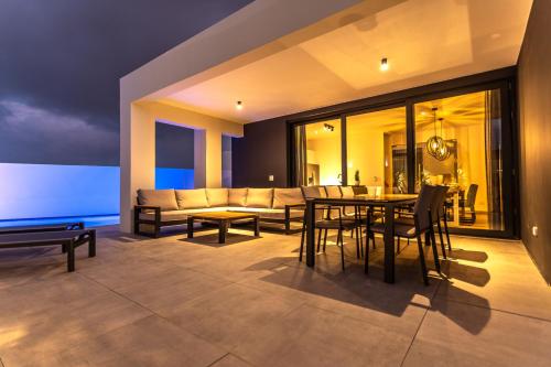 Tuscany Residence Aruba في شاطئ بالم إيغل: غرفة معيشة مع أريكة وطاولة وكراسي