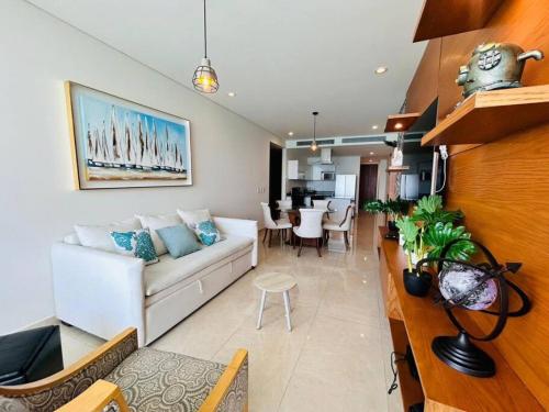a living room with a white couch and a table at Lujoso departamento frente al mar/camino al mar in Mazatlán