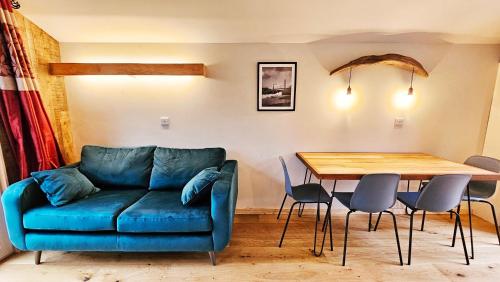 a living room with a blue couch and a table at Eagle's Nest Connemara and Mayo in Westport