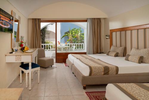 a hotel room with two beds and a desk at Le Hammamet Hotel & SPA in Hammamet