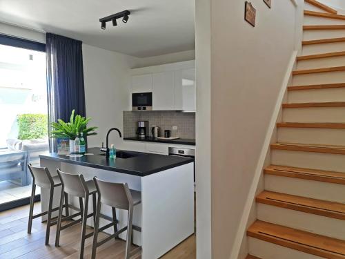 a kitchen with a black counter and stools at Tuscany Residence Aruba in Palm-Eagle Beach