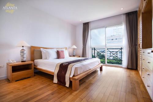 a bedroom with a bed and a large window at Atlanta Residences in Hanoi