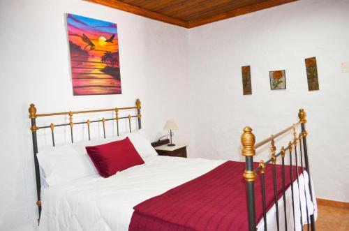 a bedroom with a bed with a red blanket at Casa Sendero de Taidia in San Bartolomé