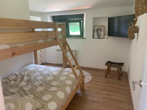 a bedroom with a bunk bed and a tv at A chousa da folgueira in Ordes