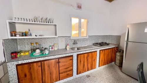 a kitchen with a sink and a refrigerator at Wadi Shab Beach House in Ramlah