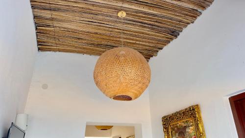 a large wicker light hanging from a ceiling at Wadi Shab Beach House in Ramlah