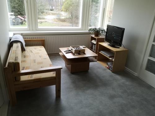 Habitación con cama, mesa y TV. en Kontiomäen retrokoti, en Kontiomäki