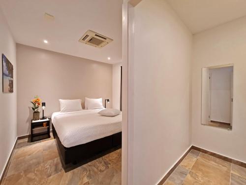 a white bedroom with a bed and a window at Tuscany Residence Aruba in Palm-Eagle Beach