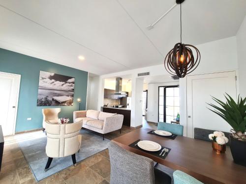 a living room with a dining table and a couch at Tuscany Residence Aruba in Palm-Eagle Beach