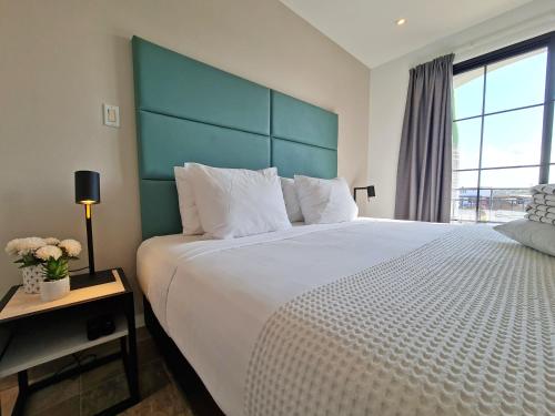 a bedroom with a large bed with a green headboard at Tuscany Residence Aruba in Palm-Eagle Beach