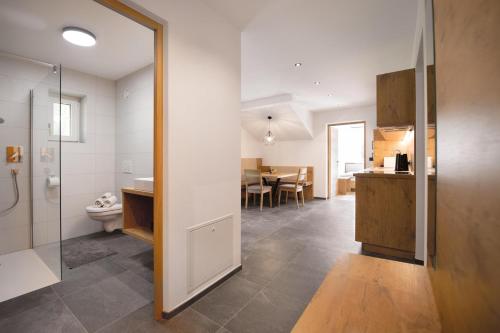 a bathroom with a toilet and a kitchen with a table at Living Miramor in Racines