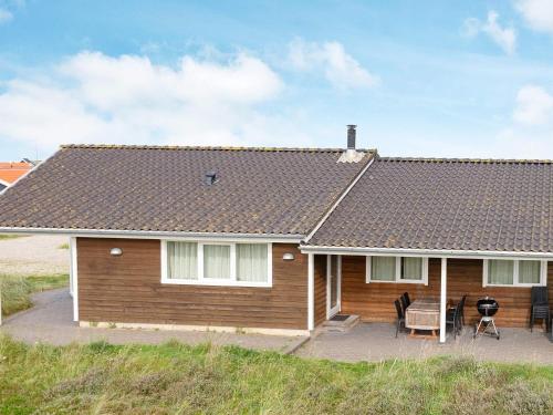 una casa con techo inclinado y patio en 10 person holiday home in Thisted, en Klitmøller