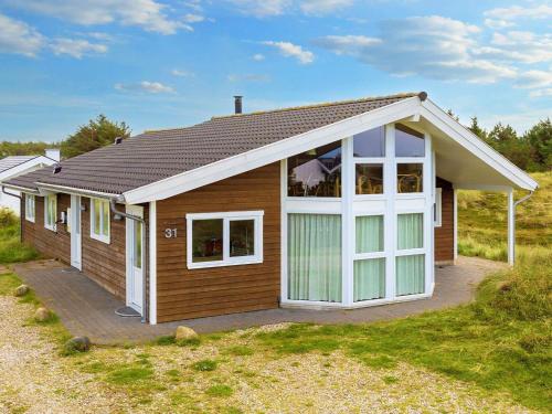 uma pequena casa de madeira com uma grande janela em 10 person holiday home in Thisted em Klitmoller