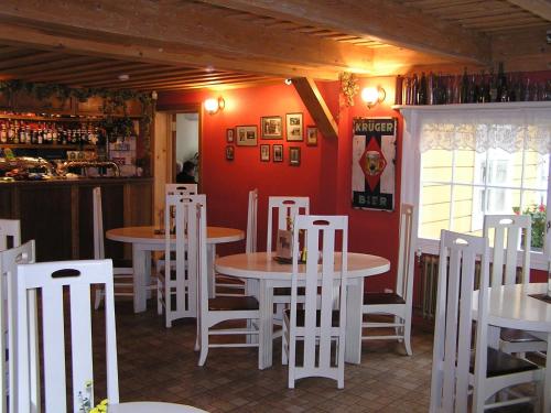 a restaurant with white tables and white chairs at Majoru Promenāde in Jūrmala