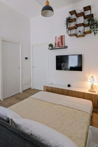 a bedroom with two beds and a tv on the wall at Pepper House - cozy apartment in Conversano