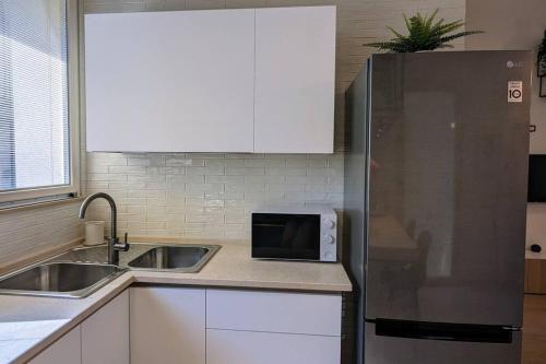 a kitchen with a stainless steel refrigerator and a sink at Pepper House - cozy apartment in Conversano