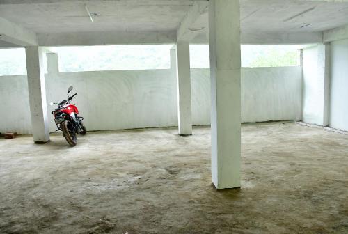 a red motorcycle parked in an empty parking lot at Hotel Pleasing Pines in Dagshai