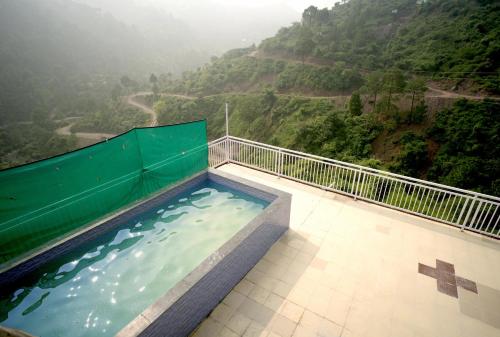 a hot tub with a view of a mountain at Hotel Pleasing Pines in Dagshai