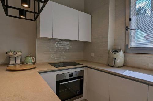 a kitchen with white cabinets and a counter top at Pepper House - cozy apartment in Conversano