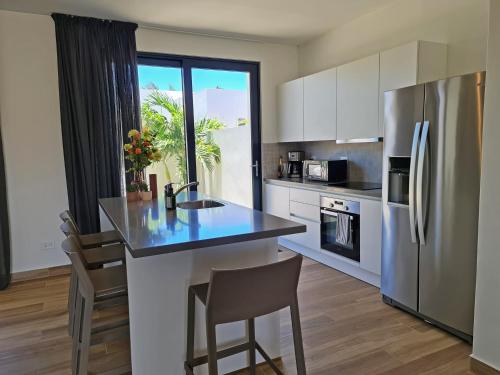 a kitchen with a sink and a refrigerator at Tuscany Residence Aruba in Palm-Eagle Beach
