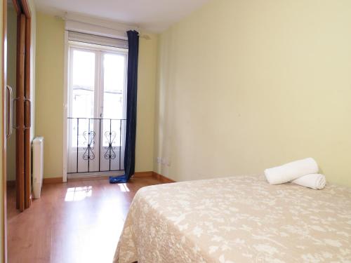 1 dormitorio con 1 cama y puerta con balcón en SAN PEDRO 64 AP, en Lugo