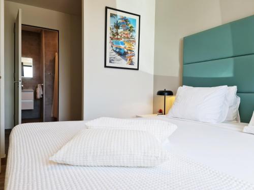 a white bed with a blue headboard in a bedroom at Tuscany Residence Aruba in Palm-Eagle Beach